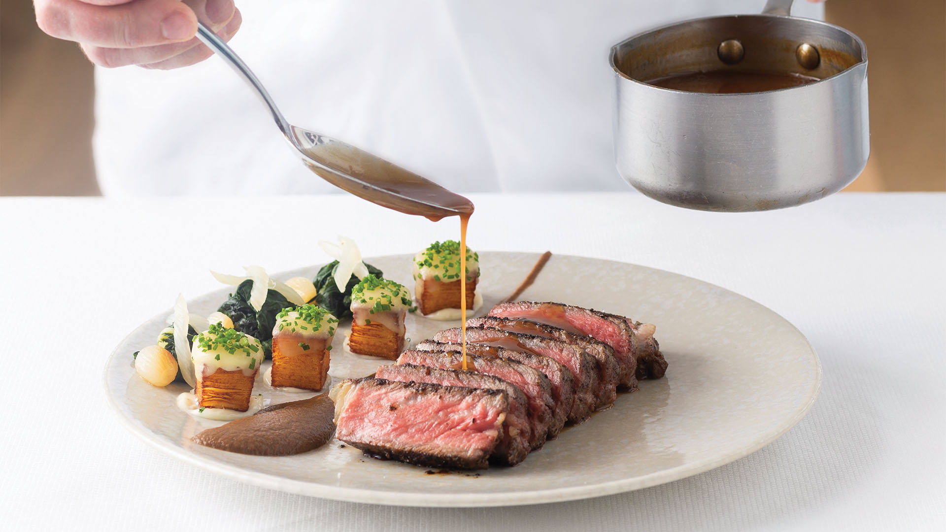 Chef preparing a premium steak at Spago