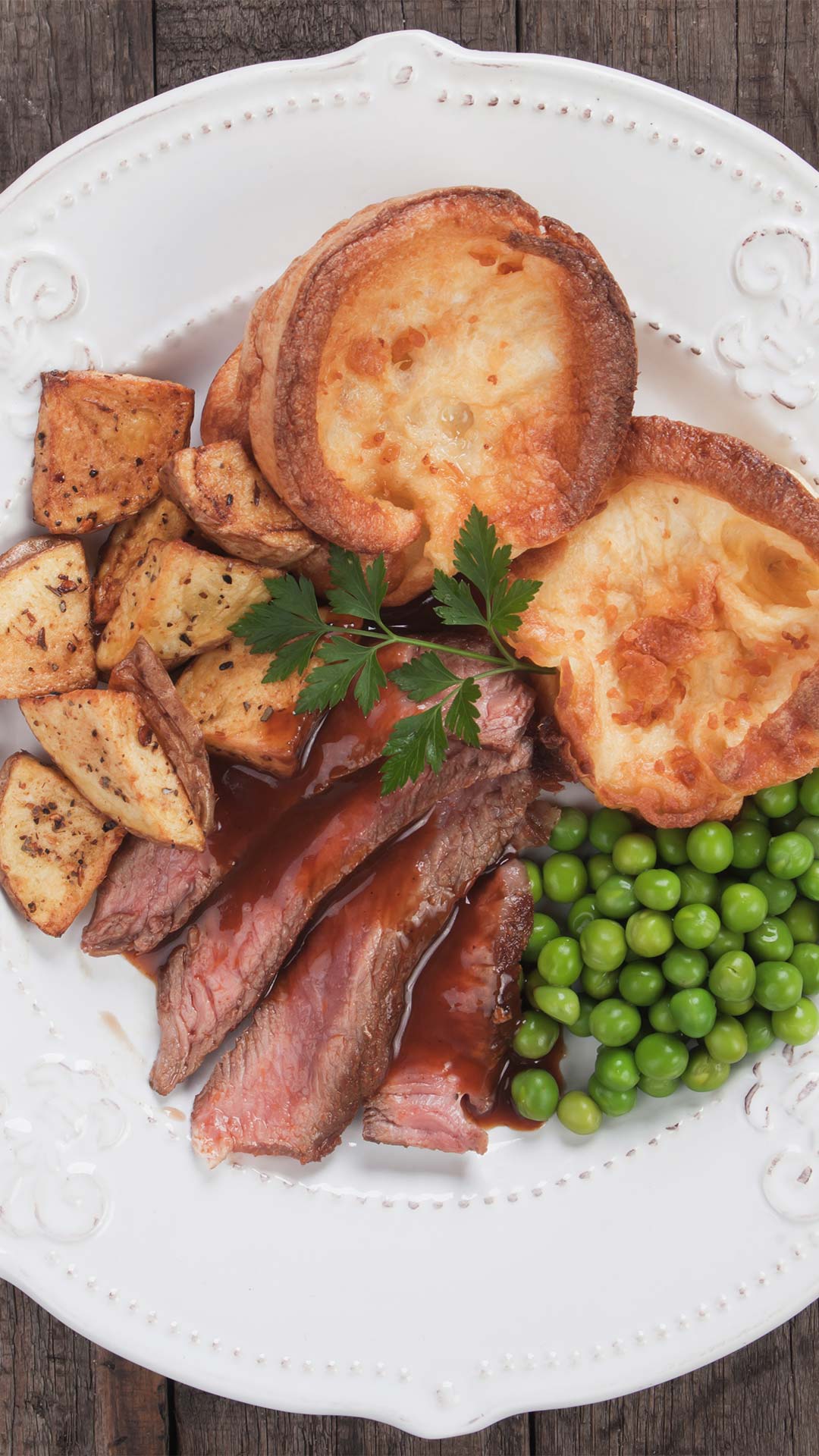 Roasted beef with Yorkshire pudding and vegetables on a plate at the best Sunday roast places in Singapore