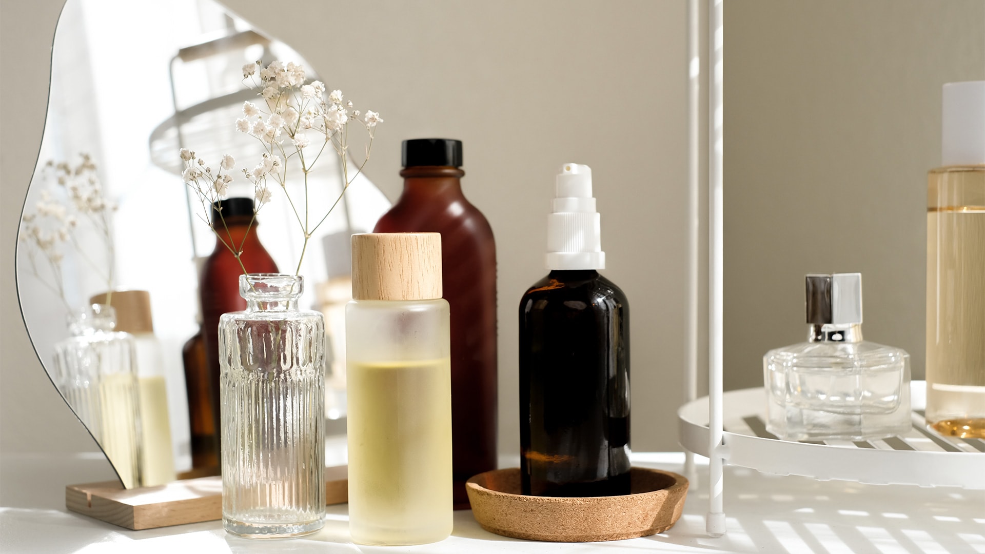 Bottles of skincare items on a vanity table from popular beauty and skincare brands