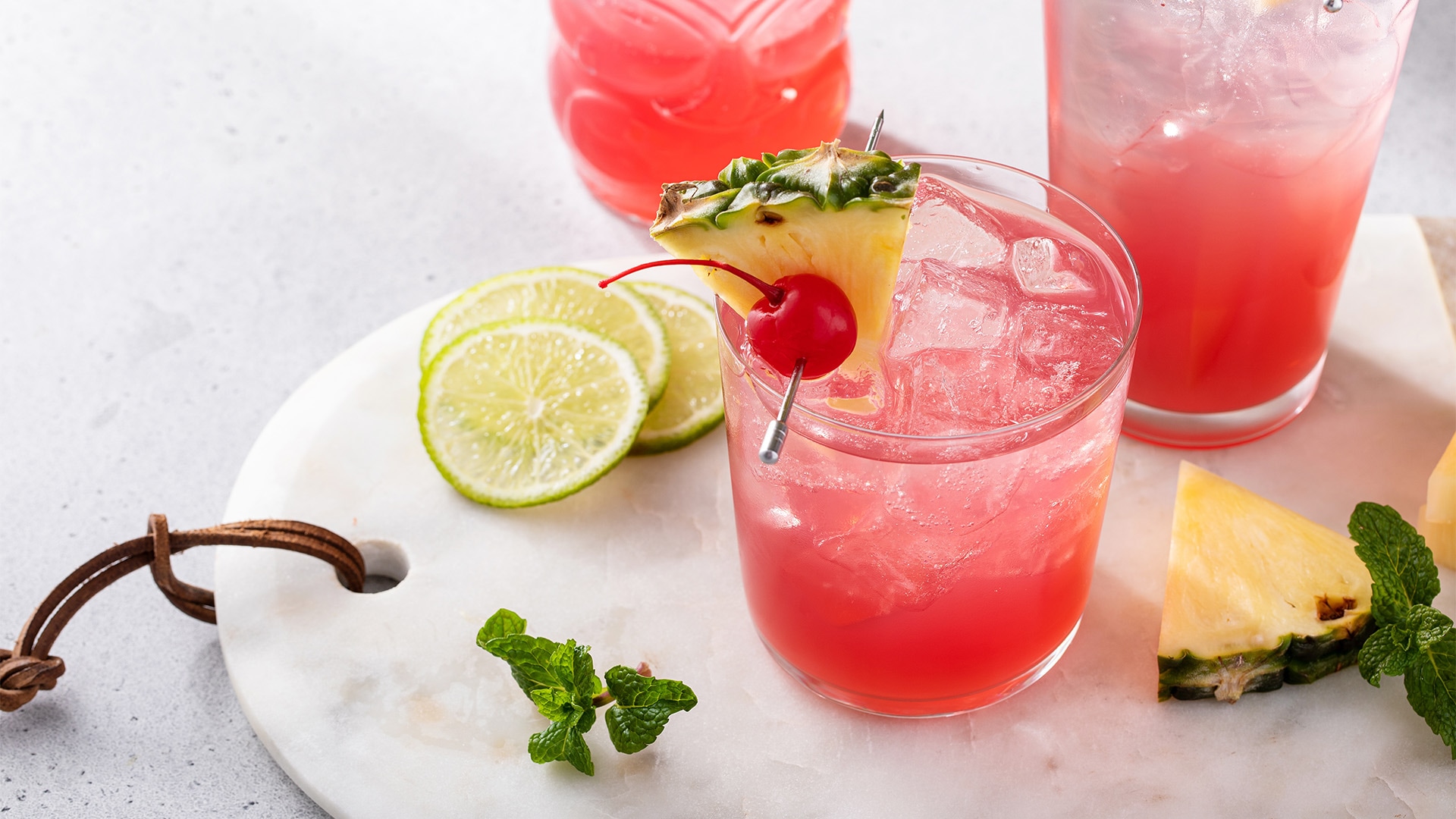 A glass of Singapore Sling, a cocktail in red with pineapple